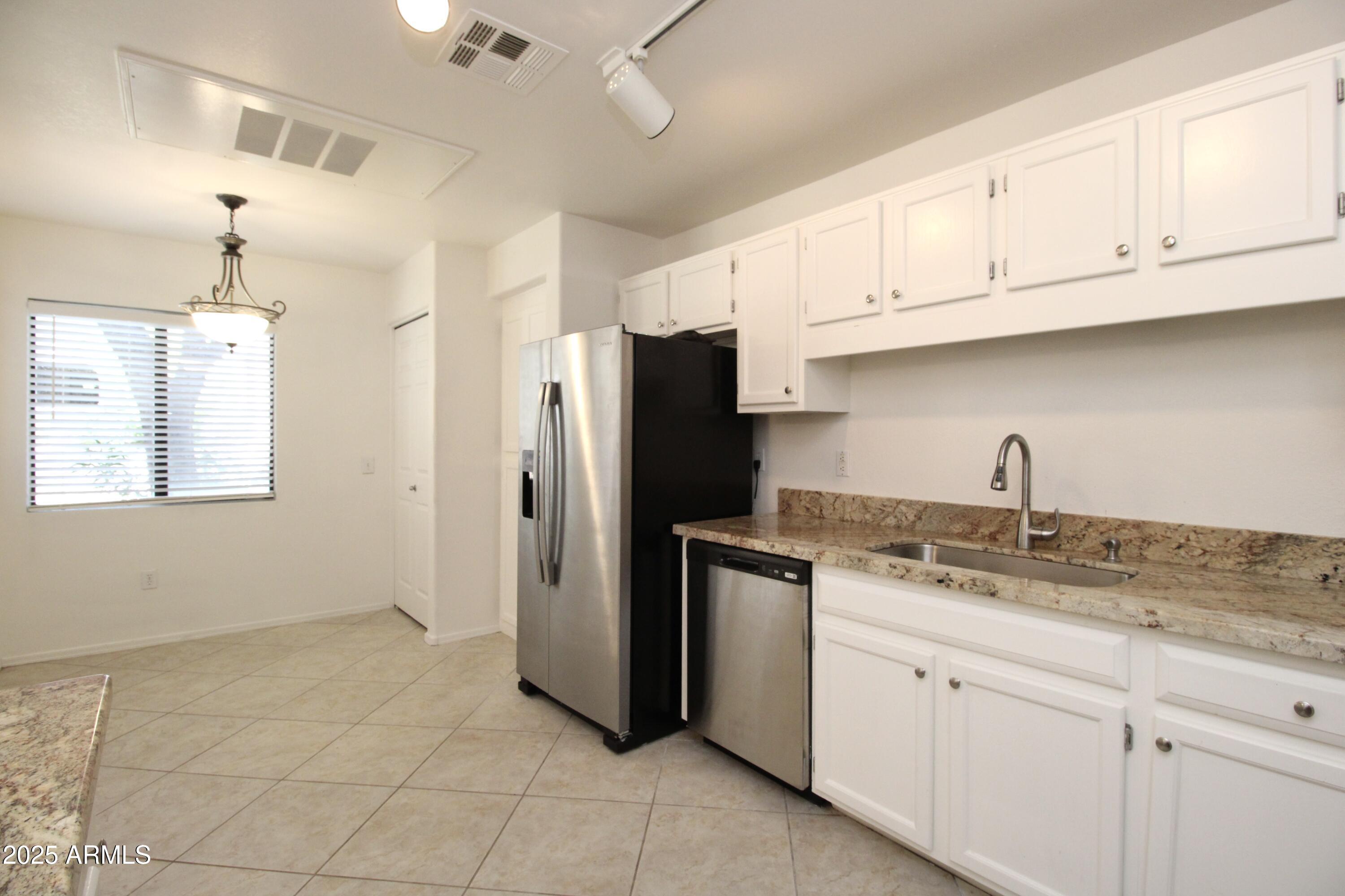 15050 North Thompson Peak Parkway, Unit 1012 Scottsdale, AZ 85260 - Photo 5 of 49 a kitchen with stainless steel appliances granite countertop a refrigerator sink and cabinets