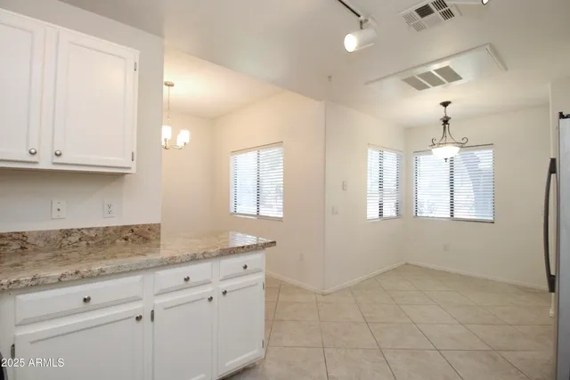 a kitchen with granite countertop white cabinets and a sink
