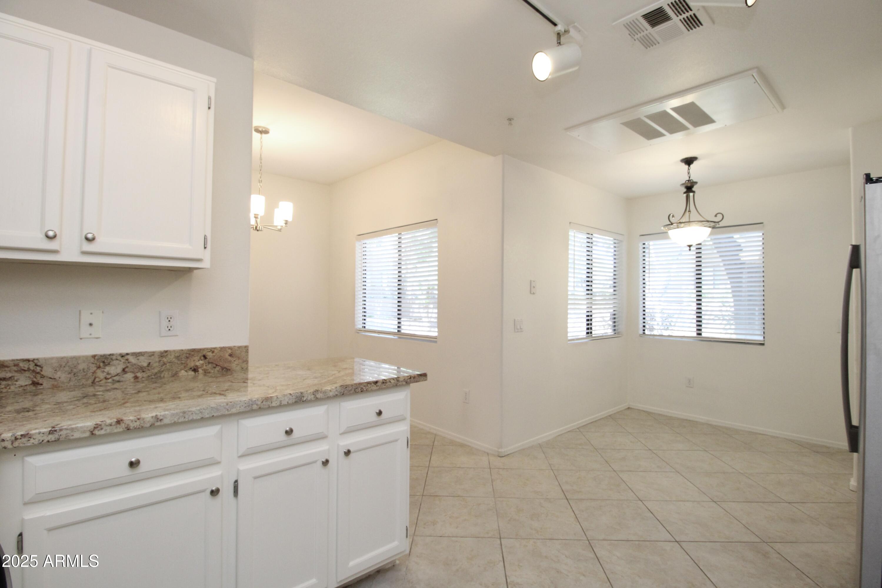 15050 North Thompson Peak Parkway, Unit 1012 Scottsdale, AZ 85260 - Photo 6 of 49 a kitchen with granite countertop white cabinets and a sink