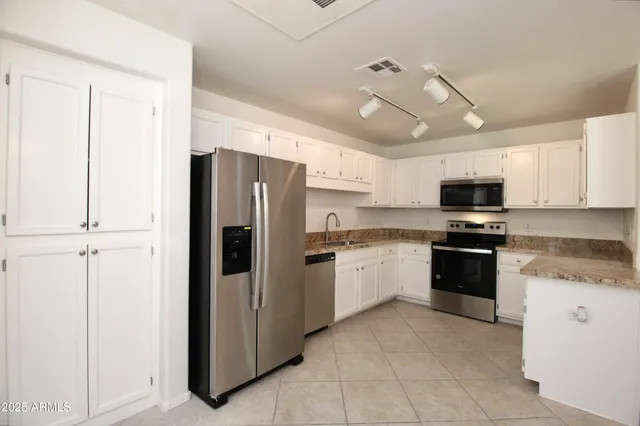 a kitchen with stainless steel appliances granite countertop a refrigerator oven a sink and dishwasher