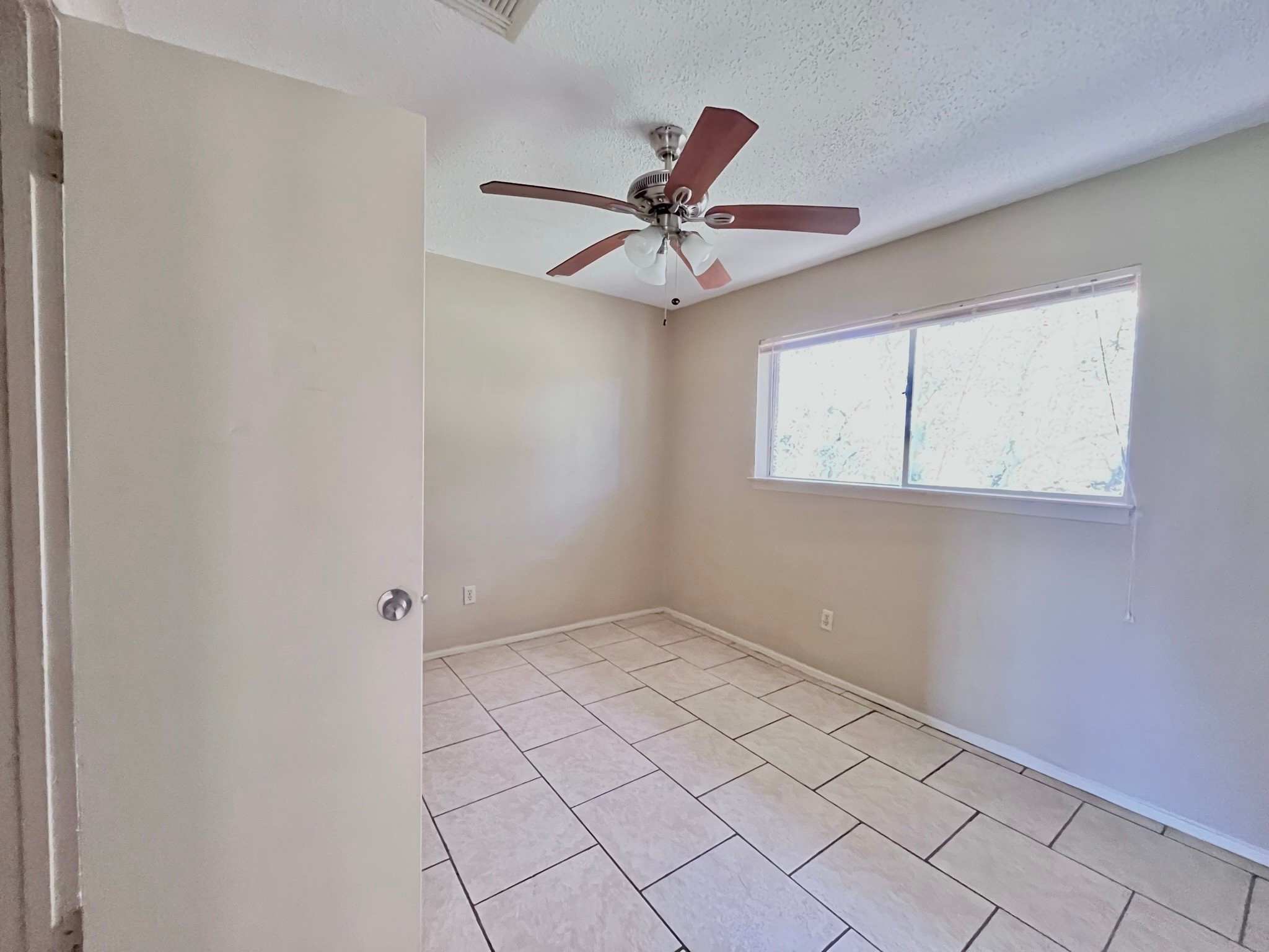 3021 Sycamore Avenue, Unit 10 Bay City, TX 77414 - Photo 9 of 12 an empty room with windows and fan