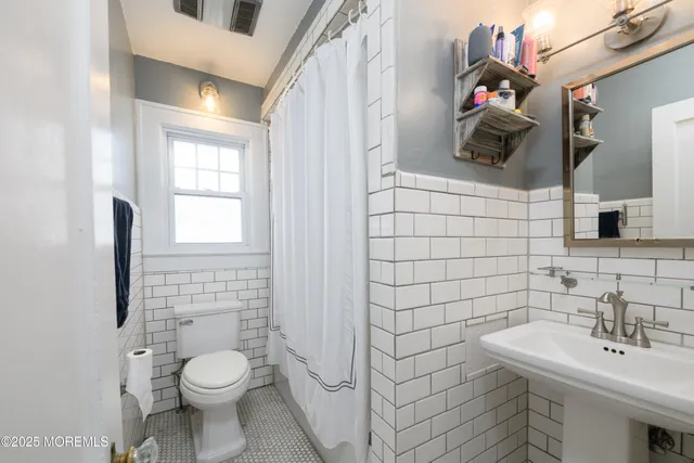 a bathroom with a sink a toilet and mirror