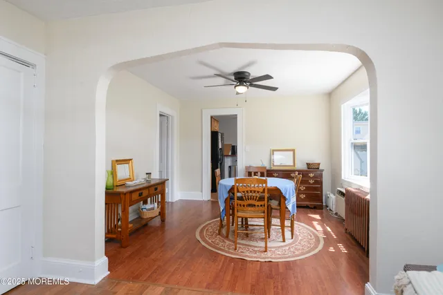 a dining room with wooden floor a chandelier a wooden table and chairs