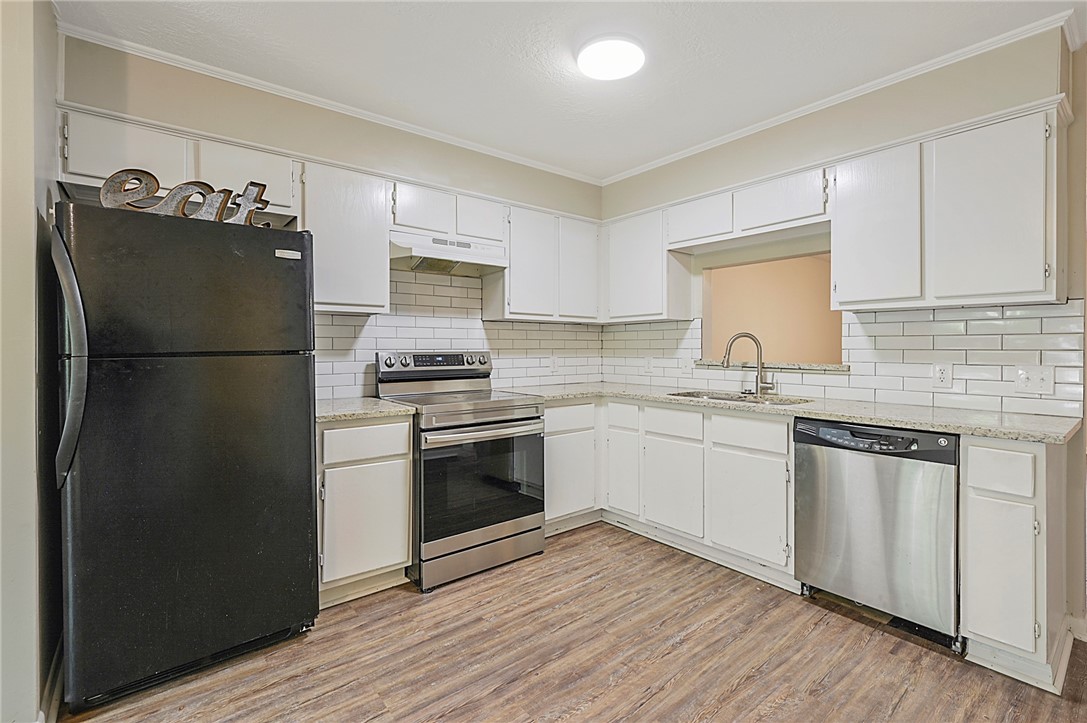 a kitchen with granite countertop a refrigerator stove and sink