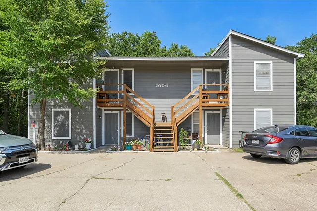 a front view of a house with parking space and a car parked in front of it