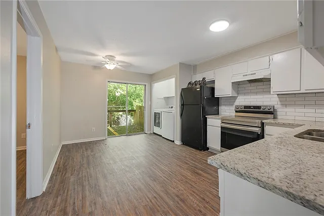 a kitchen with a refrigerator and a stove top oven