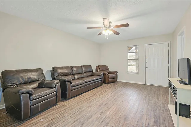 a living room with couches and a flat screen tv with wooden floor