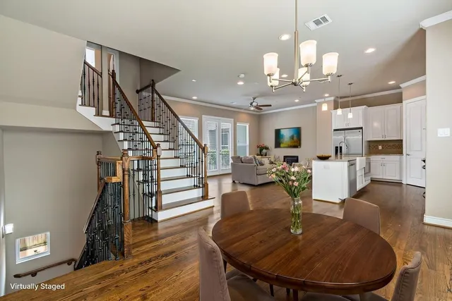 a living room with furniture kitchen view and a wooden floor