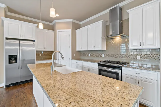 a kitchen with stainless steel appliances granite countertop a sink stove and refrigerator