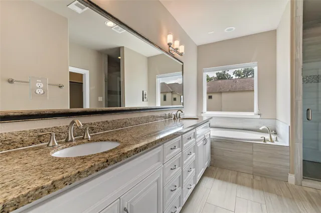 a bathroom with a granite countertop sink double and mirror