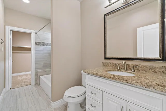 a bathroom with a granite countertop sink toilet and shower