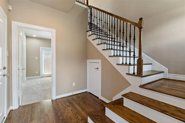 a view of staircase with railing and white walls