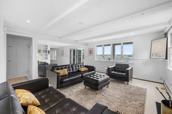 a living room with furniture fireplace and a window