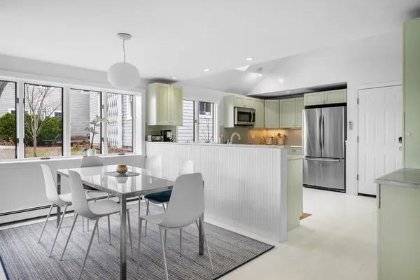 a kitchen with refrigerator a sink and chairs