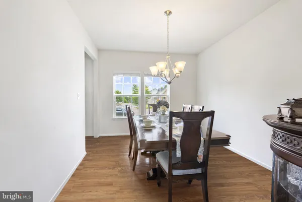 a dining room with furniture a chandelier and wooden floor