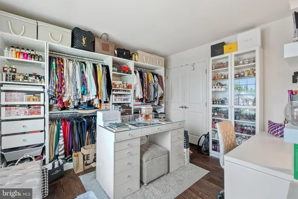 a view of walk in closet with clothes and shoes