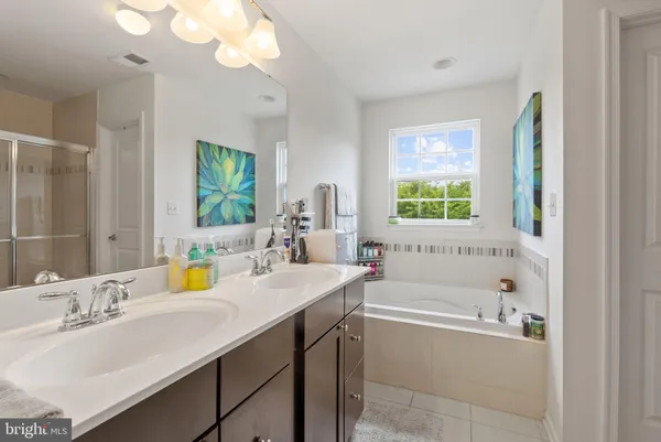 a bathroom with a tub sink and mirror