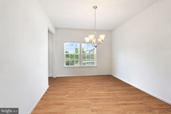 a view of an empty room with chandelier and window