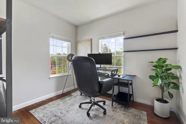 a view of a workspace with furniture and a window