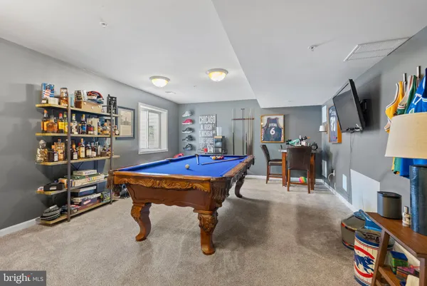 a room with furniture pool table and windows