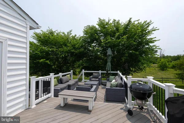 a view of roof deck with furniture and trees