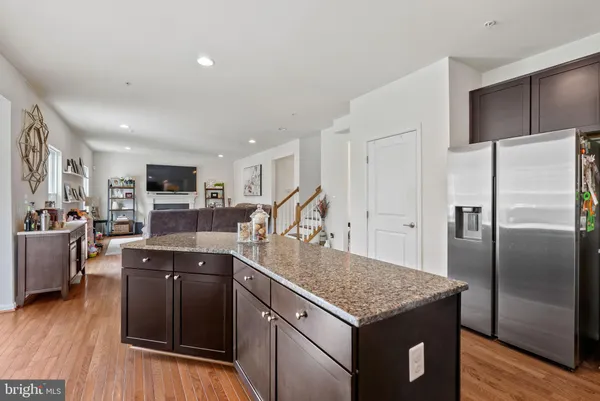 a kitchen with stainless steel appliances granite countertop a table chairs refrigerator and microwave