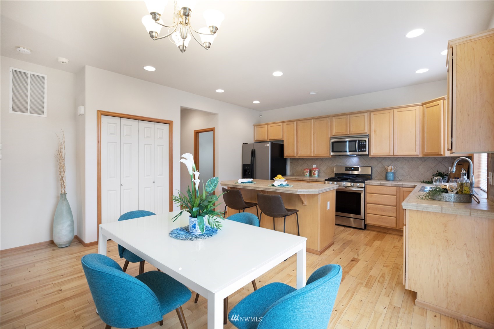 4412 Northeast 3rd Lane Renton, WA 98059 - Photo 9 of 26 a kitchen with stainless steel appliances kitchen island granite countertop a refrigerator a stove top oven a sink dishwasher and white cabinets with wooden floor