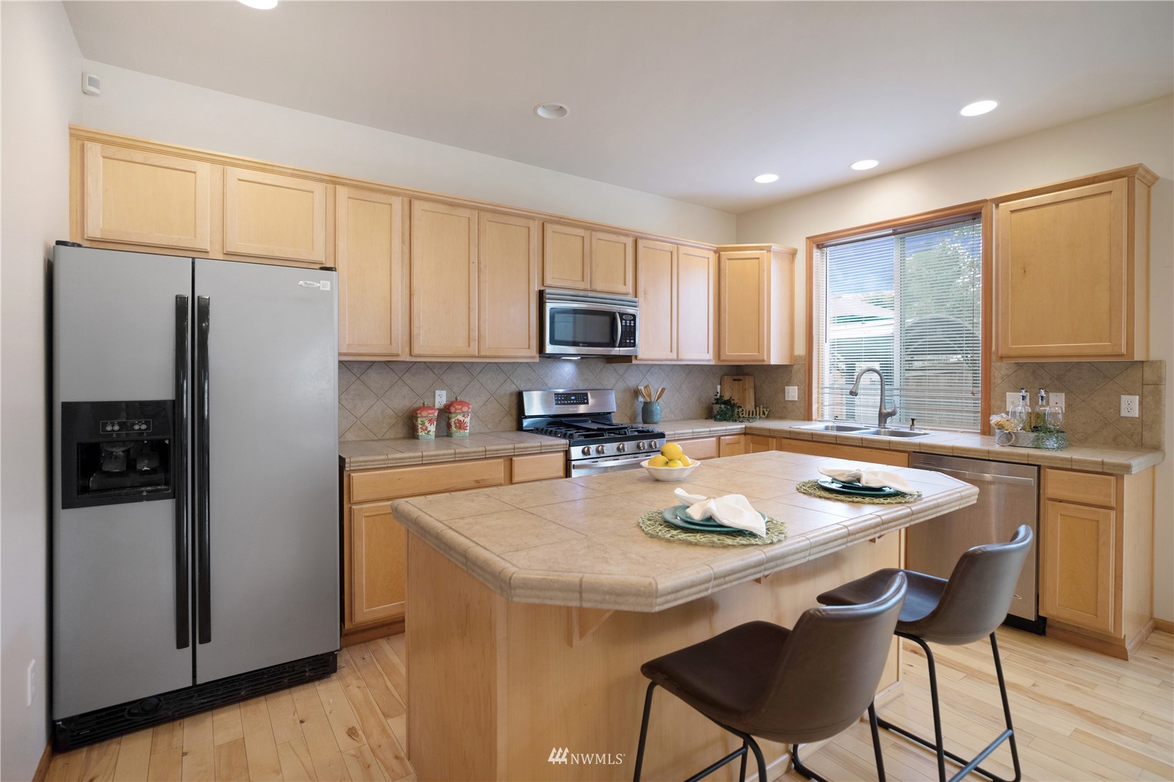 4412 Northeast 3rd Lane Renton, WA 98059 - Photo 10 of 26 a kitchen with stainless steel appliances granite countertop a refrigerator a stove a sink a dining table and chairs