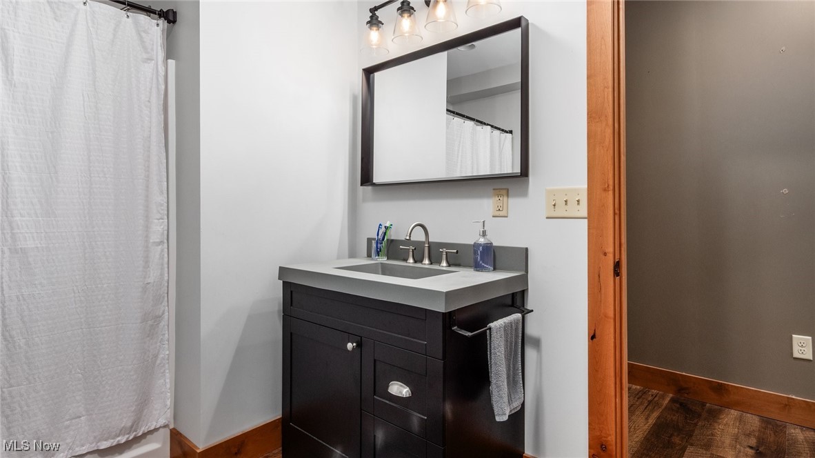 62960 James Road Cambridge, OH 43725 - Photo 33 of 40 Full bathroom featuring vanity, dark wood-type flooring, and a shower with curtain