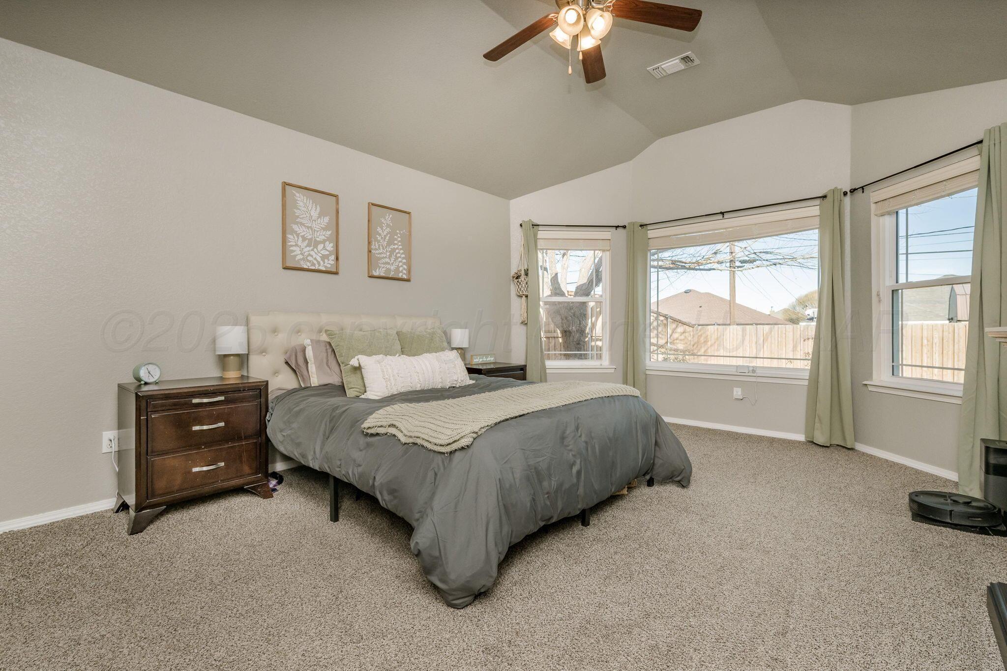 1404 Southwest 61st Avenue Amarillo, TX 79118 - Photo 15 of 30 a spacious bedroom with a bed and a chandelier