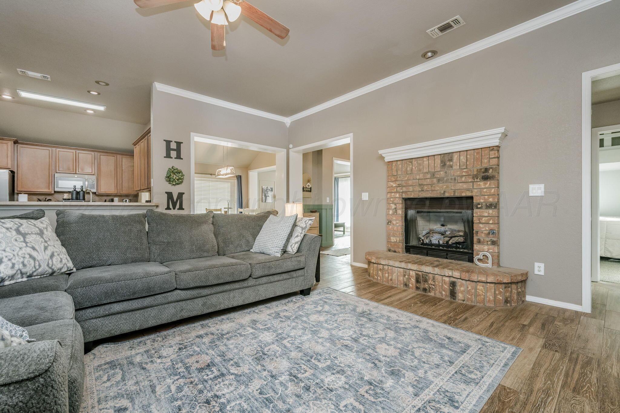 1404 Southwest 61st Avenue Amarillo, TX 79118 - Photo 7 of 30 a living room with a couch and a fireplace