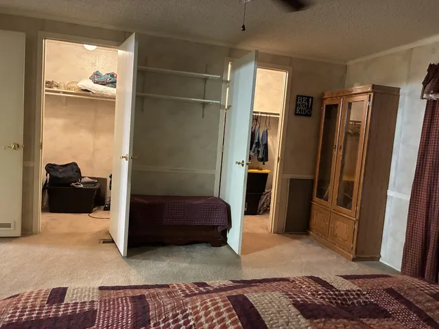 a bedroom with a bed and a refrigerator