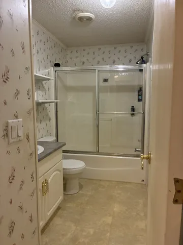 a bathroom with a shower a toilet and a shower