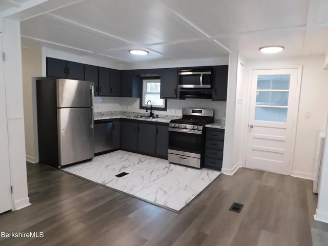 a kitchen with stainless steel appliances a stove a refrigerator and a sink