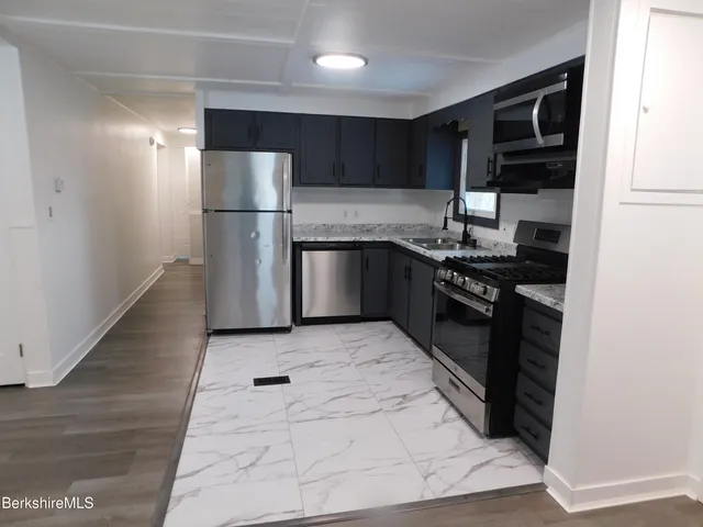 a kitchen with stainless steel appliances granite countertop a stove a refrigerator and a sink