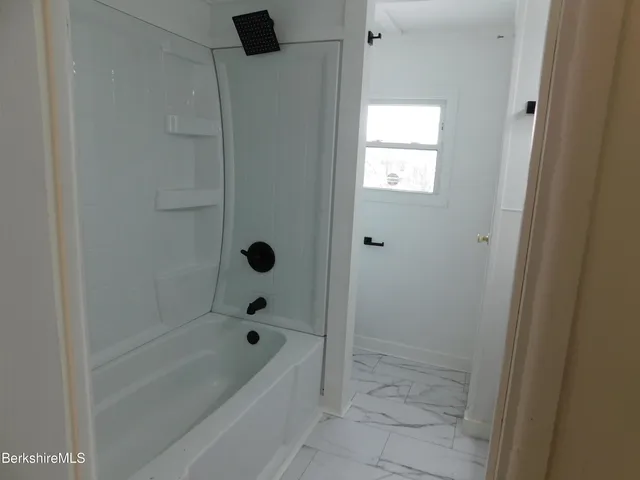 a bathroom with a bathtub and shower
