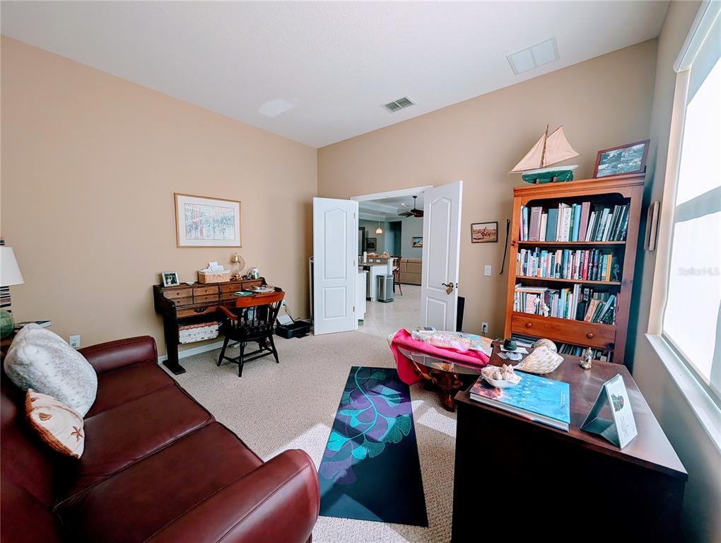 343 Marsh Creek Road Venice, FL 34292 - Photo 19 of 30 a living room with furniture and a book shelf