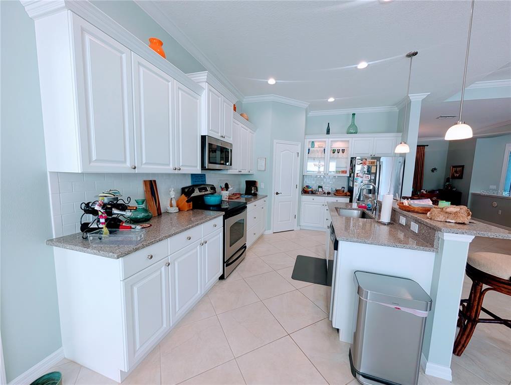 343 Marsh Creek Road Venice, FL 34292 - Photo 8 of 30 a kitchen with a sink a microwave and cabinets