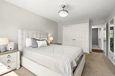 a spacious bedroom with a bed and a lamp