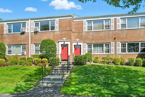 a front view of a house with a yard and outdoor seating