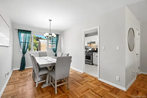 a dining room with furniture a chandelier and wooden floor
