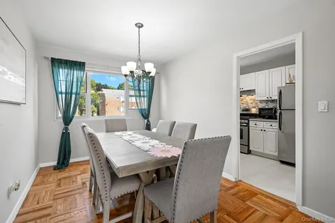 a dining room with furniture a chandelier and wooden floor