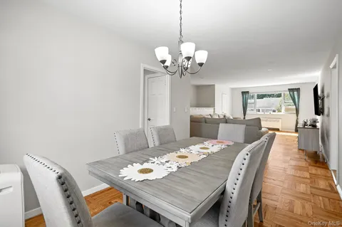 a view of a dining room with furniture a chandelier and wooden floor