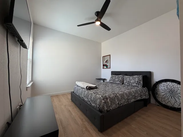 a bedroom with bed and wooden floor