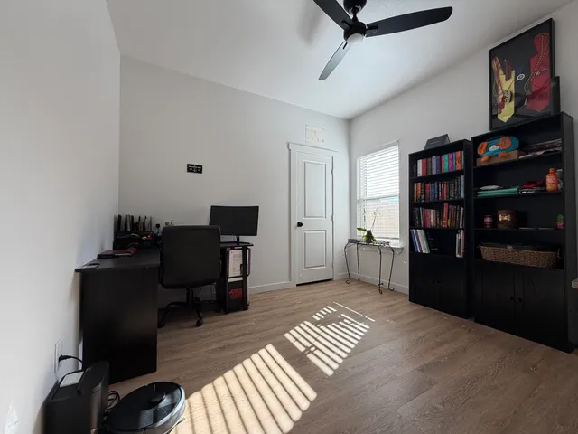 a view of a workspace with furniture and wooden floor