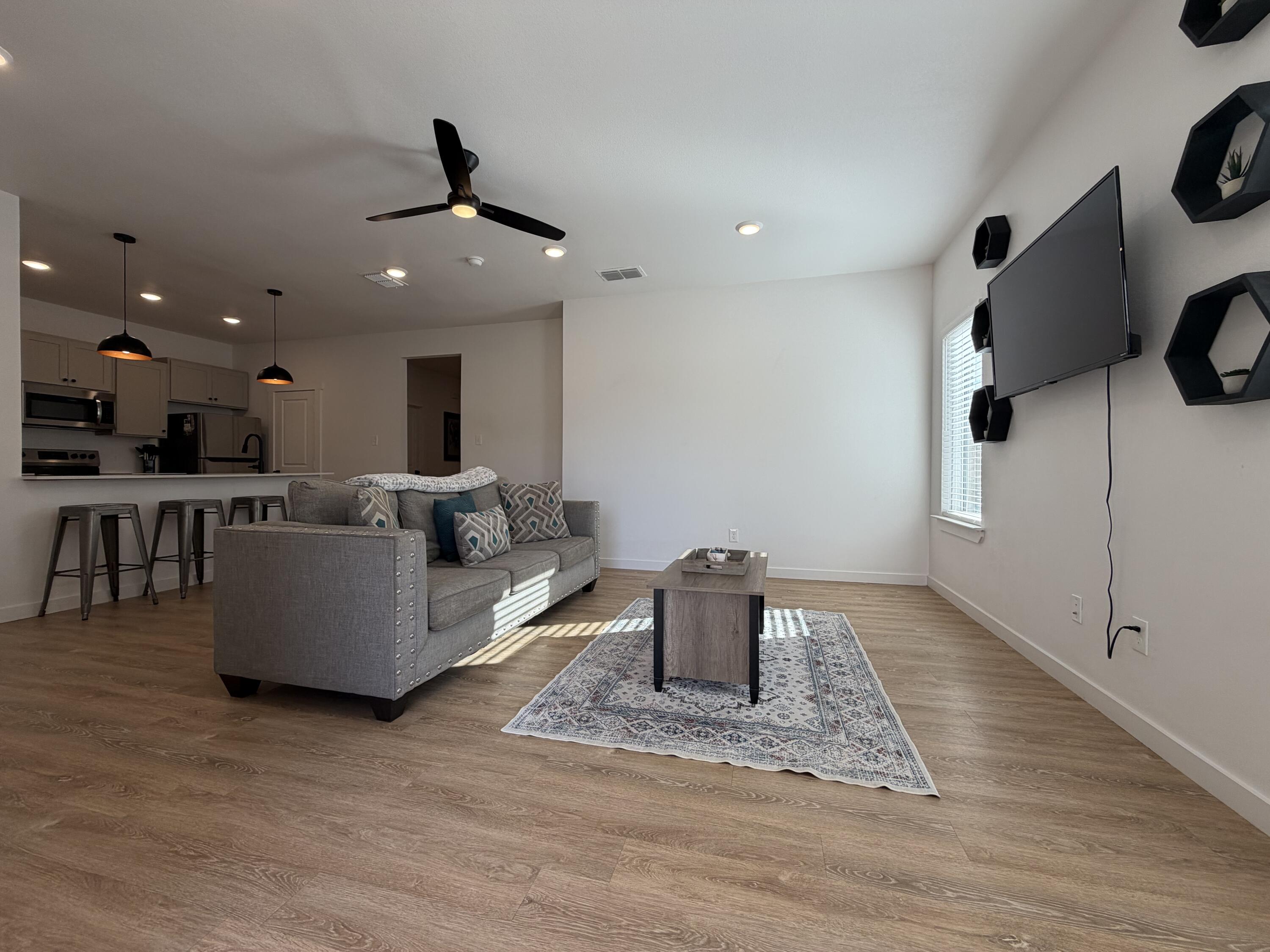 5807 Virginia Avenue Lubbock, TX 79407 - Photo 5 of 26 a living room with couches and kitchen view with wooden floor