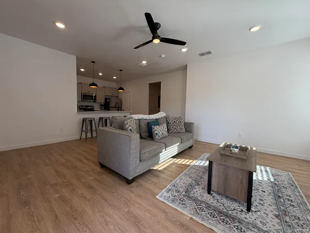 a living room with furniture and a ceiling fan