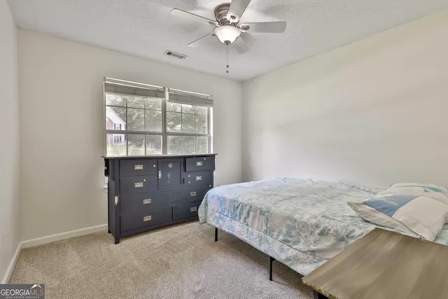 a bathroom with a granite countertop toilet and a sink
