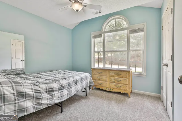 a bathroom with a granite countertop toilet sink and mirror