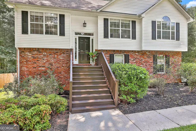 a front view of a house with a yard and potted plants